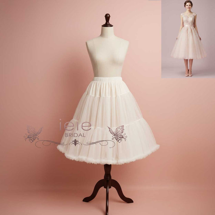 White bridal skirt on a mannequin with 'iele BRIDAL' branding against a pink background.