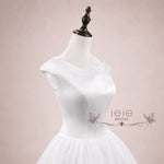 Close up of 1950s style satin bodice and voluminous tulle bridal skirt